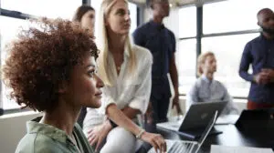 Close up of creative business colleagues listening to an informal presentation in a meeting room